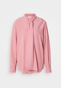 Blusa de manga longa rosa clarinho com colarinho redondo e detalhe frontal atado. Feita de um tecido suave com um corte ligeiramente solto.