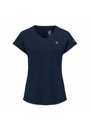 Personne aux cheveux tressés vue de dos, portant une chemise bleu marine à manches courtes et un pantalon assorti, avec une montre au poignet gauche.