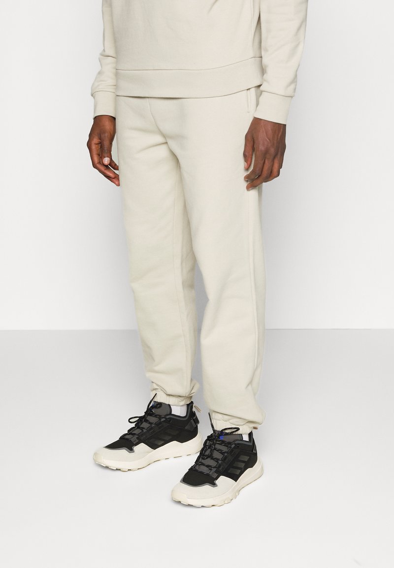 Herren Trainingsanzüge | pinqponq UNISEX Jogginghose cliff beige/beige - LS51181 Herren Trainingsanzüge | pinqponq UNISEX Jogginghose cliff beige/beige - LS51181