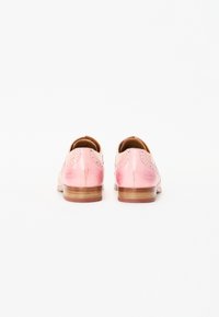 Scarpe in pelle rosa con una finitura liscia, dettagli brogue e un tacco in legno basso. Vista posteriore che mette in evidenza il design e i dettagli delle cuciture.
