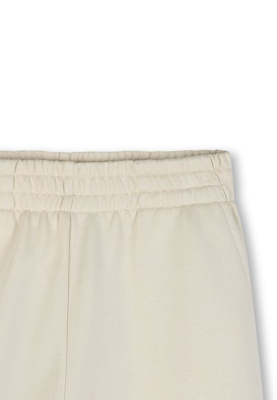 Beige sweatpants met een elastische tailleband, zichtbare naden en een gestructureerde stof.