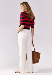 Červeno-námořnický pruhovaný svetr s krátkým rukávem doplněný bílými kalhotami s širokými nohavicemi. Dokončeno hnědou kabelkou. Hladké textury a čisté linie.