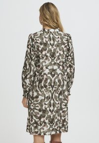 Hosszú ujjú ruha zöld és rózsaszín absztrakt mintával, könnyű anyagból készült, begyűrt ujjakkal és laza szabással.