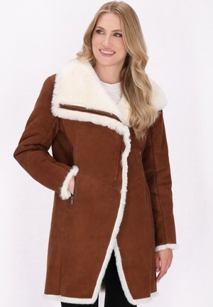 Cappotto in finta suede marrone con colletto e rifiniture in finta pelliccia bianca. Presenta tasche con zipper e un design frontale asimmetrico.