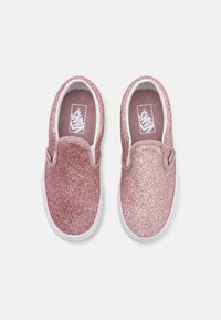 Roze glitter klizne cipele s bijelim gumenim potplatom i logotipom na unutrašnjem dijelu, s glatkom teksturom i zaobljenim dizajnom.