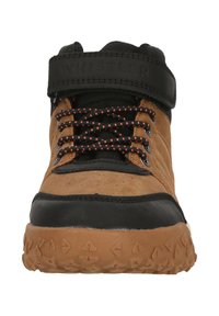 Braune und schwarze High-Top-Sneaker mit strukturierten Sohlen, schwarzen und orangefarbenen Schnürsenkeln sowie einem schwarzen Riemen mit der Aufschrift "WHISTLER" um den Knöchel.