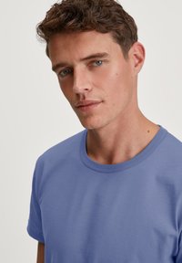 Korte mouwen crewneck t-shirt in zachte lavendelstof, kenmerkt zich door een gladde textuur en eenvoudig ontwerp, met een minimalistische en moderne stijl.