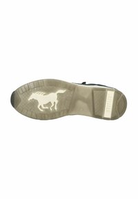 Semelle extérieure de sneaker noire avec une surface texturée, arborant une silhouette de cheval blanc et un logo "MUSTANG" dans la zone du talon.