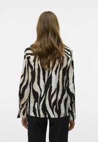 Lange mouwen shirt met een zwart en beige zebra-gestreept patroon, met een gestructureerde stof en een relaxte pasvorm, gezien vanuit de achterkant.