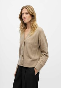 Beige wool cardigan with a V-neck, seven buttons down the front, and ribbed cuffs. Notable stitching detail along the sleeves.