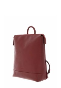 Sac à dos en cuir rouge avec une surface texturée, de forme rectangulaire, avec une poignée sur le dessus et un zip latéral pour une fermeture sécurisée.