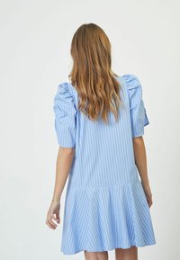 Rochie bleu cu dungi, cu mâneci bufante și fustă evazată. Confecționată dintr-un material ușor, cu dungi verticale și o croială lejeră.
