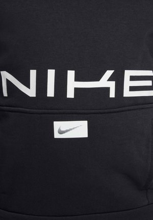 Sudadera negra con un atrevido logo en blanco de "NIKE" en la parte frontal y una pequeña etiqueta del swoosh de Nike en blanco cerca del bolsillo. Textura de tejido suave.