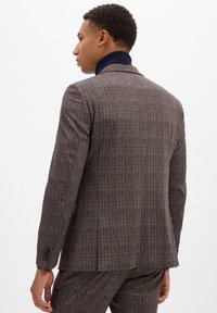 Geprüfter Blazer aus strukturiertem Stoff in Braun mit orangefarbenen und marineblauen Akzenten. Verfügt über einen Reverskragen und eine taillierte Passform.