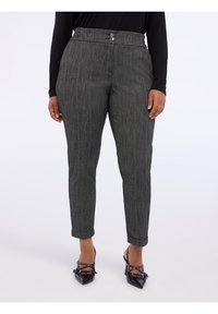 Harmaat tekstuuriset housut, joissa on räätälöity istuvuus, nappisuljenta ja käänteet nilkoissa. Yhdistetty mustiin teräväkärkisiin kenkiin.