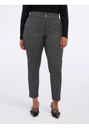 Pantaloni grigi con texture, dal taglio sartoriale, dotati di chiusura con bottone e orli alla caviglia. Abbinati a scarpe nere a punta.