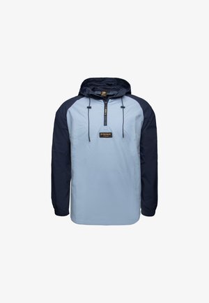 Giacca pullover di colore blu chiaro con maniche blu navy, cappuccio regolabile, fronte con mezza zip e toppa con logo. Tessuto testurizzato con polsini elastici.