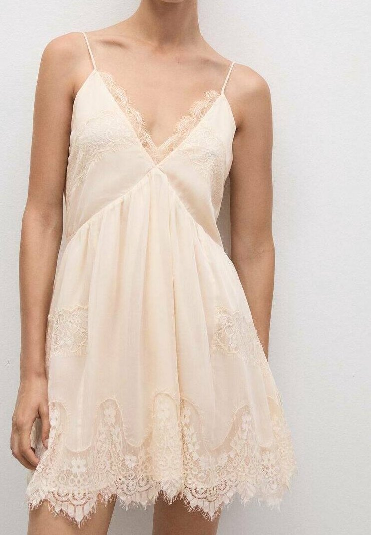 Vestido suave color melocotón con borde de encaje, tirantes finos, escote en V y forma fluida en línea A, con acentos de encaje floral en el dobladillo.