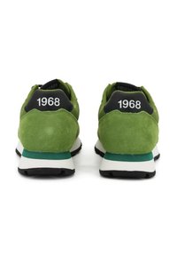Sneakers in suede verde con dettagli neri e il numero "1968" sul tallone. Presentano una suola bianca e teal con una presa testurizzata.