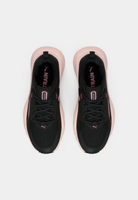 Czarne buty sportowe z różowymi akcentami, z siateczkową cholewką, amortyzowaną podeszwą i wyraźnym logo. Sznurówki są zabezpieczone dzięki pętelkowemu designowi.