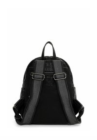 Sac à dos noir de forme arrondie, avec des bretelles à rayures chevron grises, une poignée supérieure en boucle et des accents à boucles au dos.