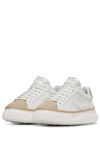 Sneakers bianchi in pelle con punta intrecciata beige testurizzata, dotati di una suola bianca spessa e chiusura con lacci. Logo sulla linguetta.