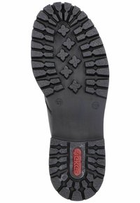 Semelle de botte en caoutchouc noir avec des rainures profondes et des motifs pour une meilleure adhérence, dotée d'un logo de marque rouge et d'un indicateur de taille en relief.