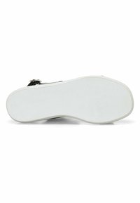 Zapato negro con parte superior de cuero liso, que presenta un perfil bajo y una suela de goma blanca texturizada. Hay una cremallera lateral visible para el cierre.