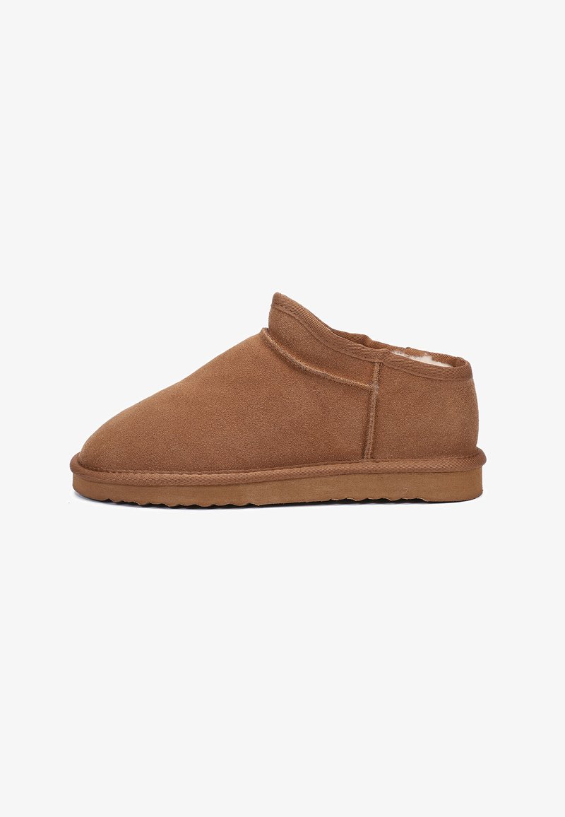 Bruine suède instapschoen met een zachte binnenvoering, ronde neus en een lage, gestructureerde rubberen zool. Stiksel details langs de zijkanten.