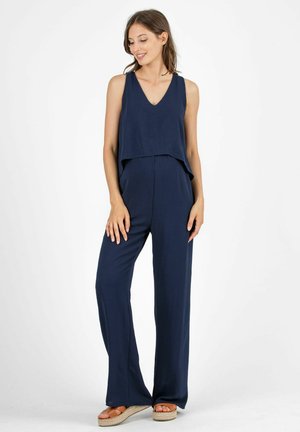 Marineblauer Jumpsuit mit einem schichtigen Design, bestehend aus einem ärmellosen Oberteil und weit geschnittenen Hosen, aus einem weichen, fließenden Stoff gefertigt.