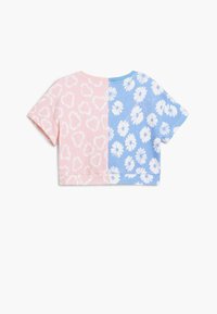 Rövid ujjú, cropped póló, rózsaszín oldallal, szívmintával és kék oldallal, fehér százszorszép mintával. Pamut anyag.