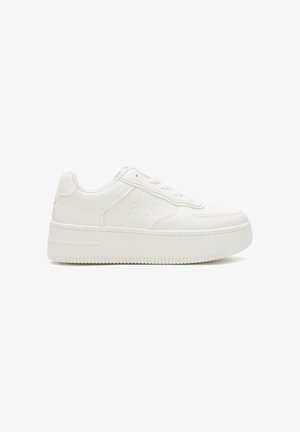 Zapatilla blanca con plataforma, cordones en la parte delantera, parte superior sintética lisa, detalles laterales perforados y suela gruesa con ranuras.