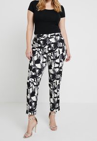 Černobílé kalhoty se vzorem, úzkého střihu, s abstraktními štětcovými vzory a vysokým pasem. V kombinaci s černým topem.