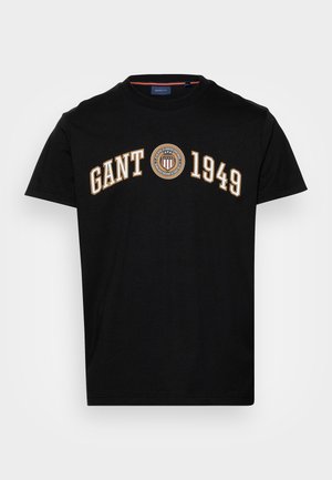 Czarny krótkozasięgowy t-shirt z okrągłym dekoltem z napisem "GANT 1949" oraz okrągłym emblematem z tarczą i gwiazdami na środku przodu.