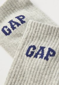 Γκρίζες ριμπ κάλτσες με μπλε γράμματα "CAP". Κατασκευασμένες από μαλακό, υφασμάτινο υλικό με πλεκτό σχέδιο στο μανίκι.