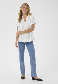 Short-sleeve, collared blouse with vertical blue and yellow stripes; paired with light blue straight-leg jeans and black flats.