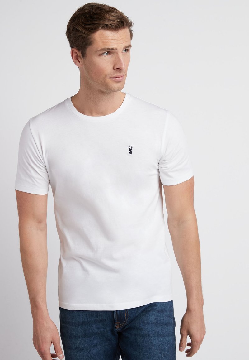 Hvid bomulds t-shirt med korte ærmer og rund hals, med et lille sort hummer-logo på venstre bryst. Bæres med blå jeans.