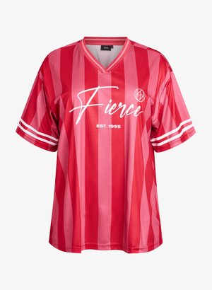 T-shirt rayé rouge et rose avec un col en V, coupe oversize, et texte blanc "Fierce" avec "EST. 1995" en dessous. Comprend des rayures blanches sur les manches.