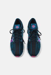 Černé a modré sportovní boty s texturovaným pleteným svrškem, růžovými detaily a vzorovanou podrážkou. Mají modré tkaničky a logo na jazyku.