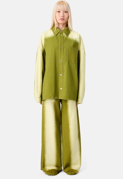 Green oversized shirt with a button front and pocket, paired with wide-leg pants featuring a gradient from light to dark green.