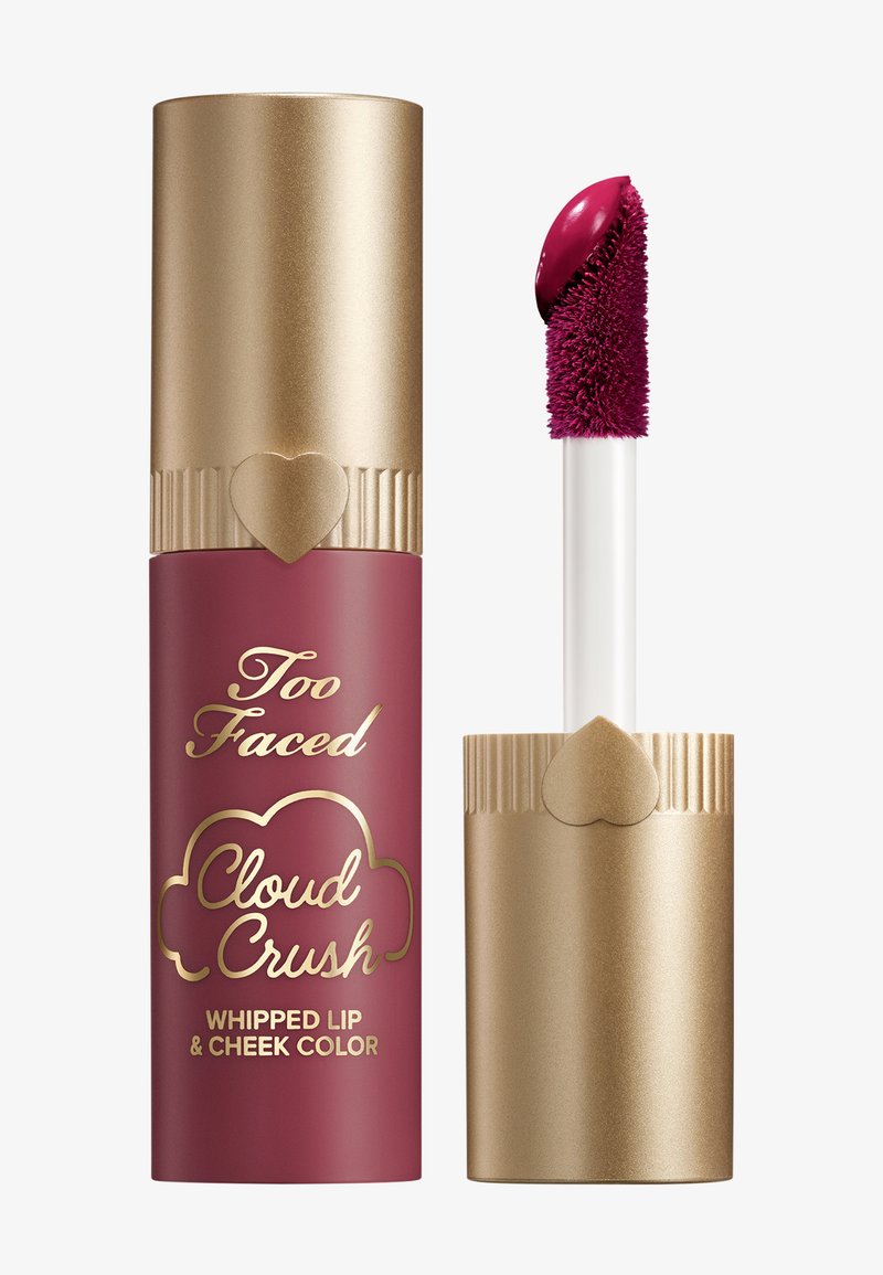 Maroon and gold lip and cheek color tube featuring a gold cap with ridged design and a heart accent, accompanied by a white applicator wand.