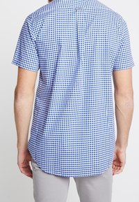 Korte mouw shirt met een blauw-wit geruit patroon, rechte zoom en een rugplooi voor extra bewegingsvrijheid.