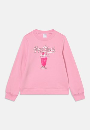 Sweat-shirt rose à manches longues avec le texte "Gap Classic" et un visuel de milkshake rose surmonté de chantilly et d'une cerise au centre.