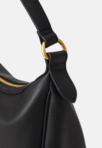 Coin de sac en cuir noir, mettant en avant un attachement en anneau en métal doré, texture lisse et détail de sangle cousue.