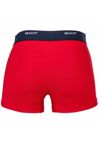 Boxer shorts in cotone rosso con elastico in vita di colore blu navy, caratterizzati dal logo GANT. Tessuto liscio e design aderente con un taglio elegante.