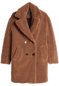 Brun teddyjacka i ett mjukt texturerat tyg, dubbelknäppt design, stor krage, två framfickor och svarta knappar.