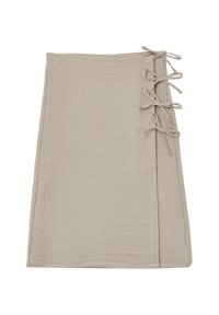 Jupe portefeuille beige en tissu doux, avec une texture lisse et des accents lacés sur un côté.