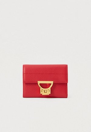 Raudona tekstūruota odinė piniginė su uždengimu ir auksinės spalvos metaliniu užsegimu ant baltos fono.