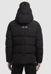 Jachetă puf de culoare neagră cu glugă, având o textură matlasată, detaliu reflectorizant pe spate și un design elegant, modern.