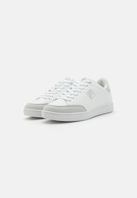 Sneakers bianchi con tomaia in pelle liscia, dettagli in suede grigio, lacci piatti e suola in gomma. Presenta un logo discreto sul lato.